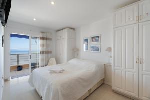 une chambre blanche avec un lit et une vue sur l'océan dans l'établissement Casa Puesta del sol, à Acantilado de los Gigantes 30 autres photos