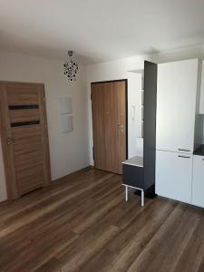 ein leerer Raum mit einem Kühlschrank und einem Holzboden in der Unterkunft Apartament 24 Gdynia Zachód in Wiczlino