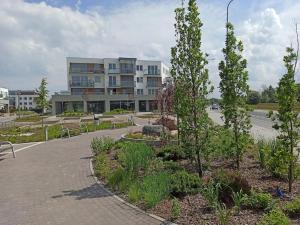 ein Park mit Bänken vor einem Gebäude in der Unterkunft Apartament 24 Gdynia Zachód in Wiczlino