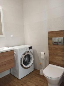ein Badezimmer mit Waschmaschine und Toilette in der Unterkunft Apartament 24 Gdynia Zachód in Wiczlino