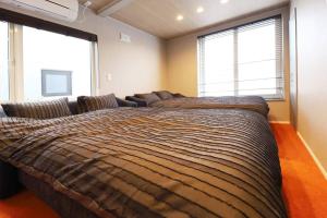 a large bed in a room with two windows at SapporoCity Ark Coat 302 LuxuryRoom in Minami-jūichijō