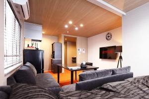 a living room with a couch and a table and a kitchen at SapporoCity Ark Coat 302 LuxuryRoom in Minami-jūichijō
