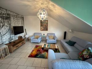 a living room with a couch and chairs and a tv at Crazy Home in Hückelhoven