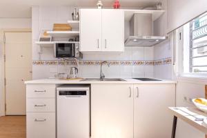 a white kitchen with white cabinets and a sink at Sunstay Center Flat I Arroyo De La Miel in Benalmádena