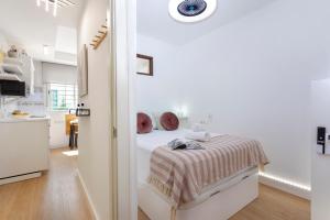 a white bedroom with a bed and a kitchen at Sunstay Center Flat I Arroyo De La Miel in Benalmádena