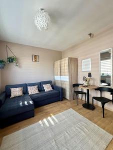 a living room with a blue couch and a table at ApartStars Powstańców #17 in Rzeszów