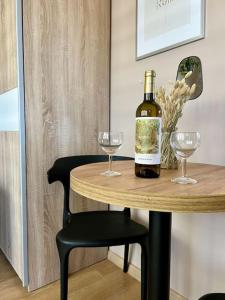 a bottle of wine on a table with two glasses at ApartStars Powstańców #17 in Rzeszów