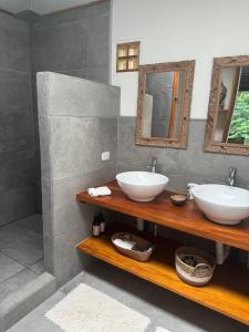 a bathroom with two sinks and two mirrors at Casa Luminosa jungle villa in Cocles