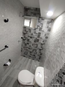 une salle de bain avec toilettes et un mur carrelé dans l'établissement superapartamento GIRADOT-RICAURTE, à San Rafael