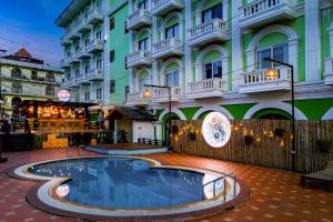 a building with a swimming pool in front of it at Lisha Roungnakhone Hotel in Vang Vieng