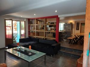 a living room with a black couch and a table at Trein d'Ustou in Ustou