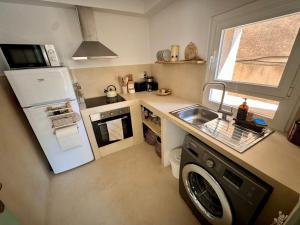 a small kitchen with a refrigerator and a dishwasher at Casa Forta, charm between vines in Capmany