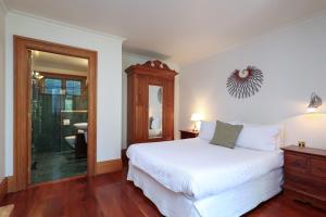 une chambre avec un lit blanc et un miroir dans l'établissement Abel Abode -Te Whare Rangi, à Nelson