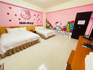 a hotel room with two beds and hello kitty on the wall at 亞舍斯電梯民宿Asias Homestay in Taitung City