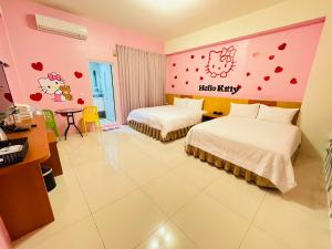 a hotel room with two beds and a hello kitty wall at 亞舍斯電梯民宿Asias Homestay in Taitung City