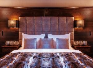 a bedroom with a large bed with a wooden headboard at Boutiquehotel Säumler in Zell am Ziller