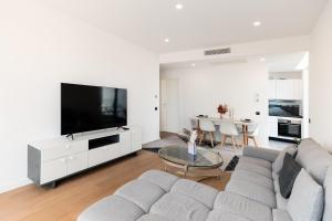 a living room with a couch and a tv and a table at Maison - Luxury Apartment in Exclusive Herastrau Area in Herăstrău