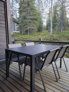une table noire et deux chaises sur une terrasse dans l'établissement Vuosselin Tähti, à Ruka