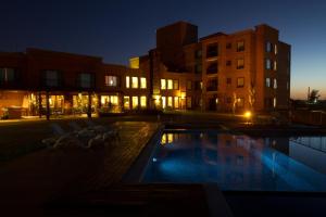 una piscina con sillas y edificios por la noche en Regency Park Hotel, en Montevideo