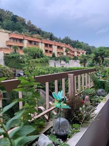 a balcony with a garden with a building in the background at Ferienwohnung Studio Bella Verde in Lesa