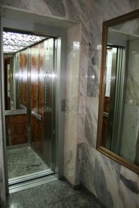 a bathroom with a glass door and a mirror at Rincón Extremeño in Plasencia
