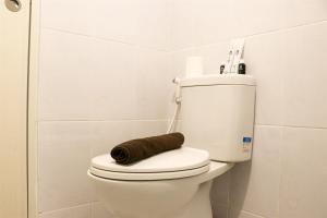 RawalembangComfort and Minimalist 2BR Apartment Tokyo Riverside PIK 2 By Travelio的浴室里的马桶上有一个棕色的卷 更多13张照片