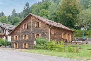 a wooden barn with windows on the side of a road at La Ferme aux Myrtilles - Ancienne ferme vosgienne in Ventron