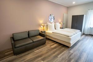 un dormitorio con una cama y un sofá en Flora Comfort Inn, en Oberhausen
