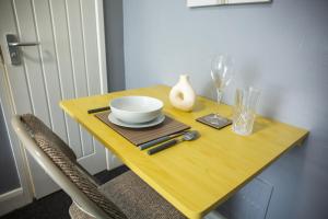 a wooden table with a bowl and a wine glass at 34 Evesham Road - Studio Apartment in Shottery +18 photos