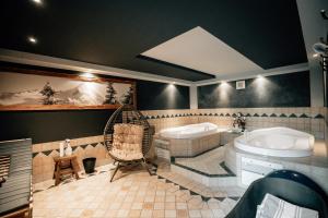 un ampio bagno con due vasche e un lavandino di Hotel Sonnberg a Saalbach Hinterglemm