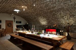 a long table with benches in a room with a brick wall at Remushof Jagschitz in Oslip