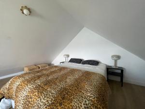 a bedroom with a leopard print bed in a attic at Ty Lazo: Sérénité en bord de mer, havre de paix. in Plouézec +20 photos