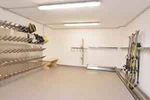 a room with skis on the wall and a bench at Garnì Villa Elsa in Pozza di Fassa