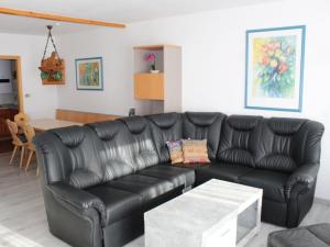 - un canapé en cuir noir dans le salon dans l'établissement Ferienhaus Nr 35, Kategorie Komfort L, behindertenfreundlich, Feriendorf Hochbergle, Allgäu, à Bichel