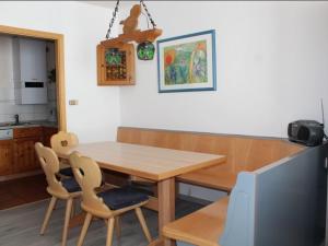 une salle à manger avec une table et des chaises en bois dans l'établissement Ferienhaus Nr 35, Kategorie Komfort L, behindertenfreundlich, Feriendorf Hochbergle, Allgäu, à Bichel