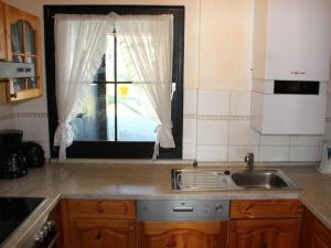 une cuisine avec un évier et une fenêtre dans l'établissement Ferienhaus Nr 35, Kategorie Komfort L, behindertenfreundlich, Feriendorf Hochbergle, Allgäu, à Bichel