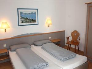 - deux lits dans une chambre avec deux lampes et une chaise dans l'établissement Ferienhaus Nr 35, Kategorie Komfort L, behindertenfreundlich, Feriendorf Hochbergle, Allgäu, à Bichel