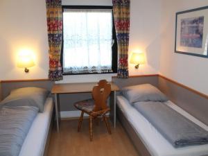 une chambre avec deux lits, un bureau et une fenêtre dans l'établissement Ferienhaus Nr 35, Kategorie Komfort L, behindertenfreundlich, Feriendorf Hochbergle, Allgäu, à Bichel 12 autres photos