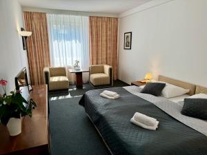 a hotel room with two beds and two chairs at A-Austerlitz Hotel in Brno +53 photos
