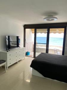 a bedroom with a bed and a view of the ocean at Listen the TIDE -201 A in Costa Del Silencio