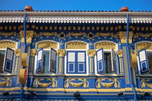 um edifício ornamentado com janelas azuis e amarelas em CUBE Boutique Capsule Hotel at Kampong Glam em Singapura