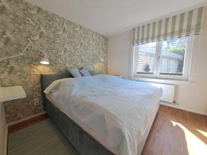 ein Schlafzimmer mit einem Bett und einem Fenster in der Unterkunft Die Muschel in Kobbellück