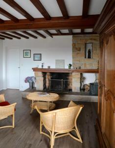 Una sala de estar con una mesa y una chimenea de piedra. en Villa facing sea and beach 7 pers 1 baby, en Barneville-Carteret