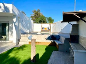 un patio con césped con un banco y una mesa en Minichalet El Molino 1, en Chiclana de la Frontera