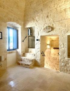 a stone walled bathroom with a sink and a window at Suite LA PETRA in Ceglie Messapica