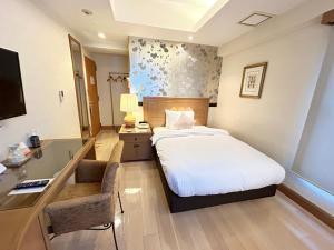 a hotel room with a bed and a desk at ホテルピュリッツァー自由が丘 in Tokyo