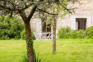 a table and chairs in the yard of a stone house at Hortensias - plage 5min en voiture in Plobannalec-Lesconil