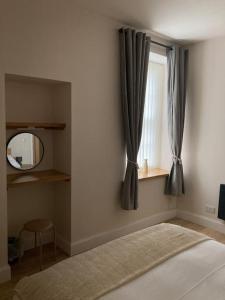 丁沃尔One bedroom Flat in Dingwall的一间带床、镜子和窗户的卧室