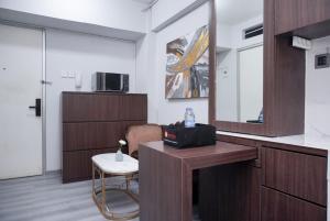 a living room with a table and a mirror at Nice and Simply 2BR at Green Bay Pluit Apartment By Travelio in Jakarta +26 photos