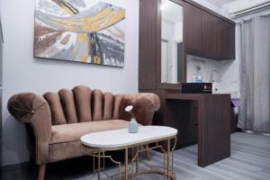 a living room with a couch and a table at Nice and Simply 2BR at Green Bay Pluit Apartment By Travelio in Jakarta